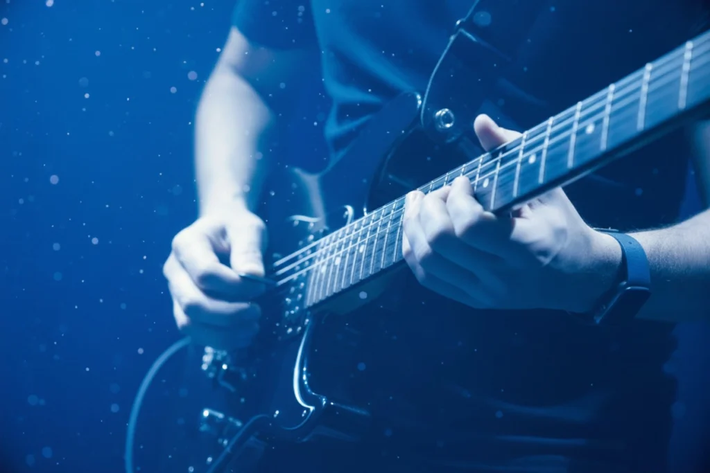 Création de signature sonore illustrée par un guitariste en studio chez Brandy Sound