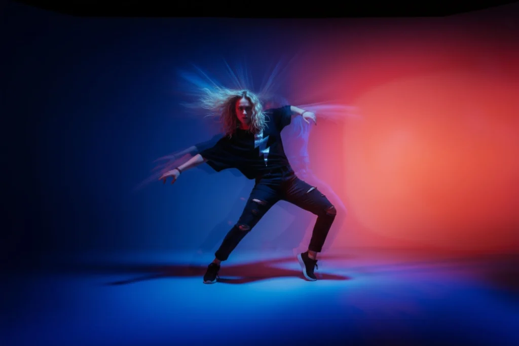 Dynamic dancer surrounded by motion blur and vibrant blue and red lighting, illustrating the emotional impact of sonic branding and brand sound identity.