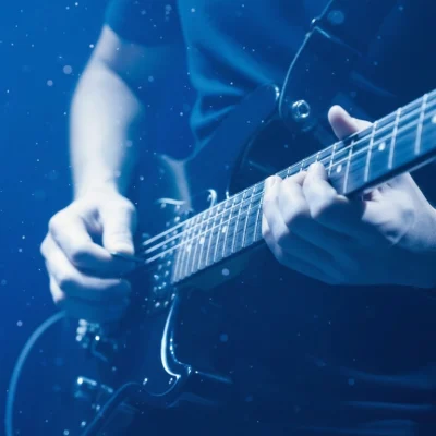 Musicien en studio enregistrant une guitare pour la création d’une identité sonore sur mesure, illustrant le prix et la production d’un projet d’audio branding.